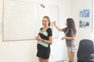 Etudiants qui font des exercices de français sur un tableau blanc