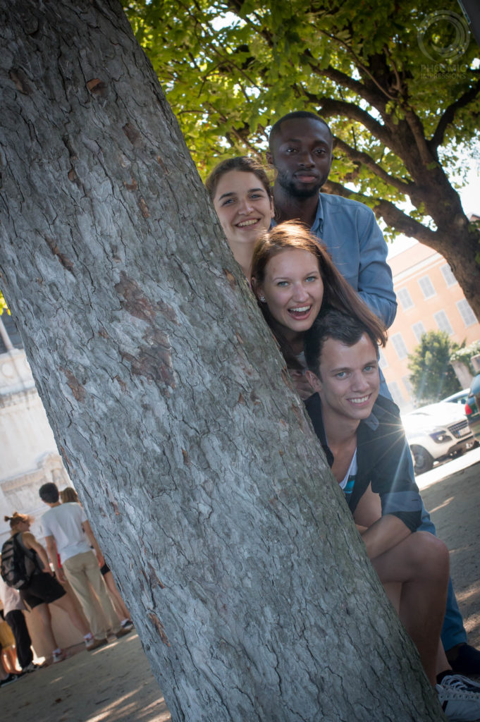 International students in Lyon hiding behind a tree